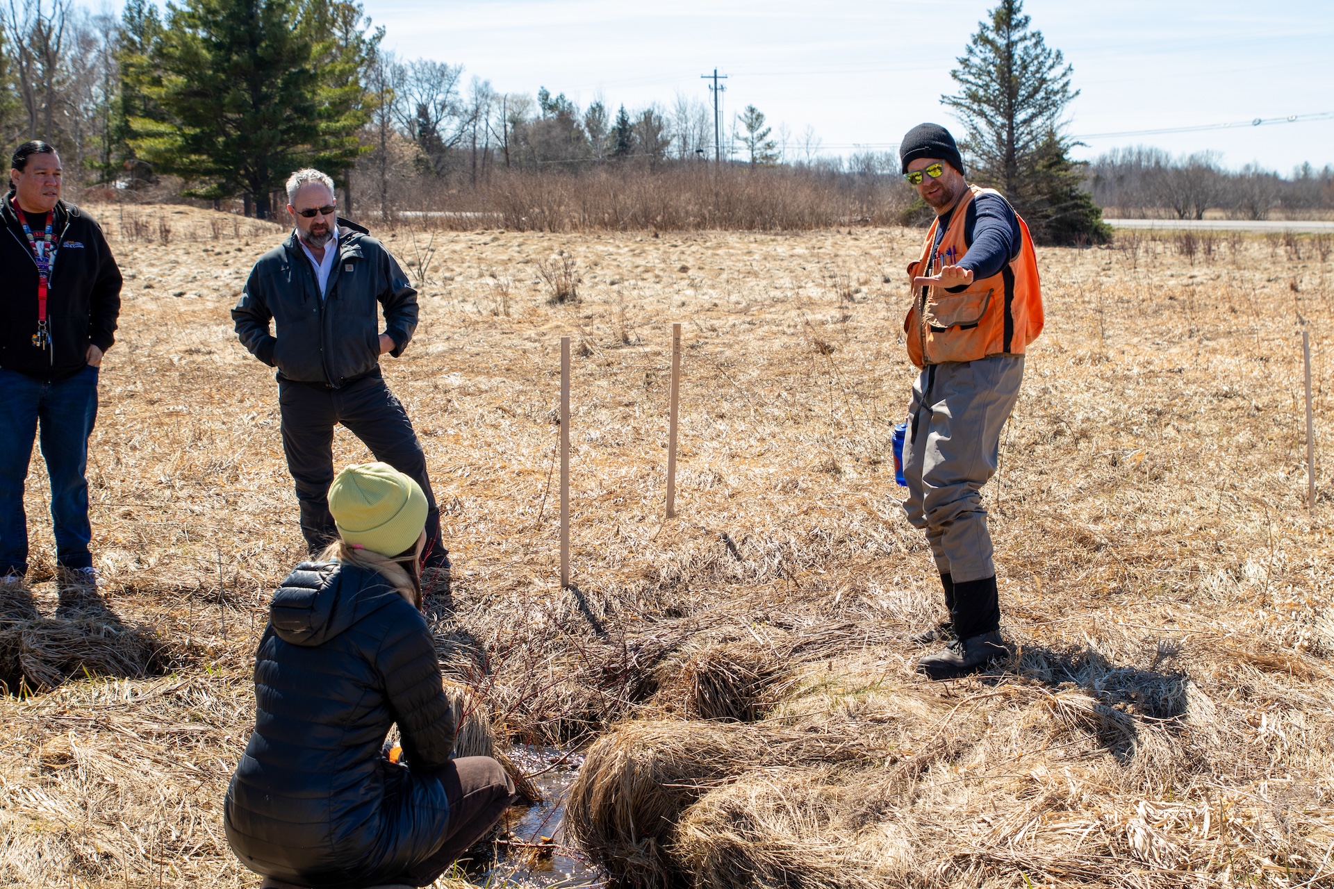 Project partners review restoration plans along a stream at Mitchell Creek Meadows Nature Preserve.